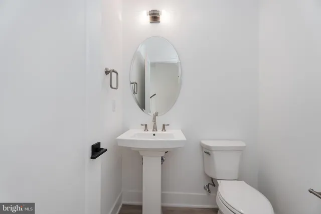 a bathroom with a sink toilet and a mirror