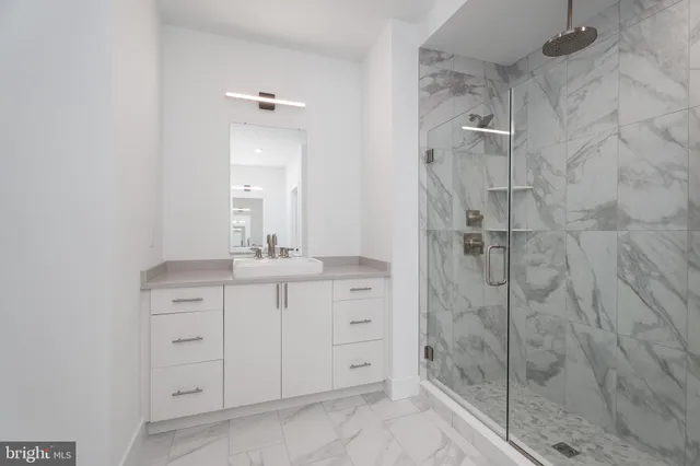 a bathroom with a shower sink and mirror