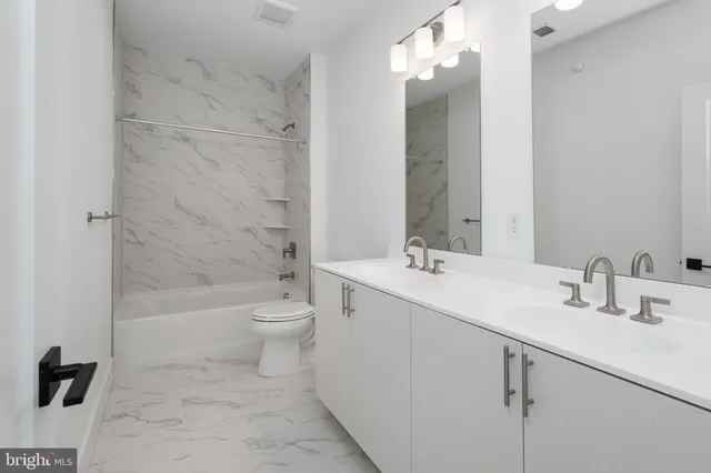 a bathroom with a double vanity sink toilet and shower