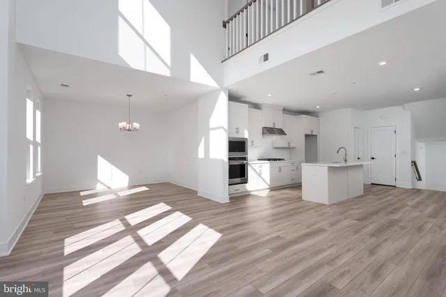 a open kitchen with white cabinets and wooden floor