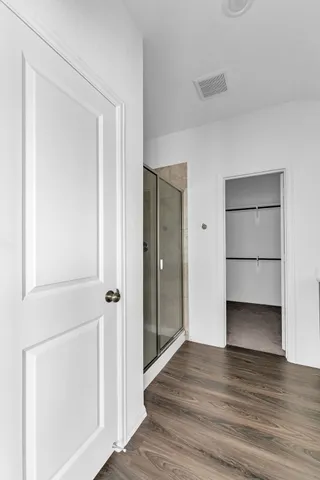 a view of empty room with wooden floor