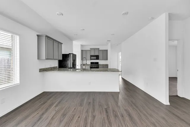 a view of kitchen with wooden floor and electronic appliances
