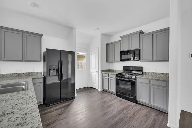a kitchen with stainless steel appliances granite countertop a refrigerator stove and sink