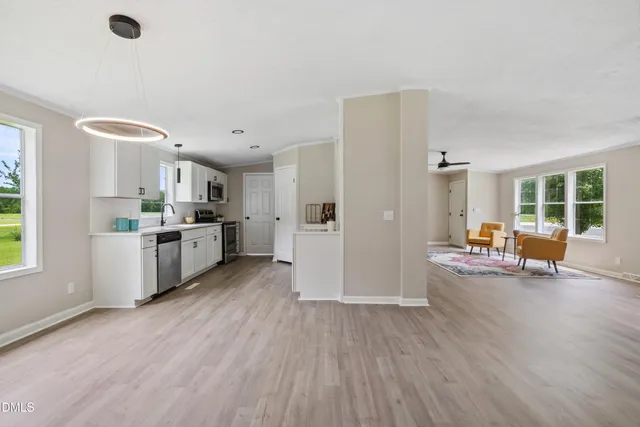 a view of a kitchen with furniture and wooden floor