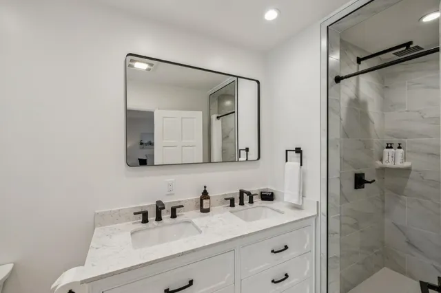 a bathroom with a bathtub shower sink and mirror