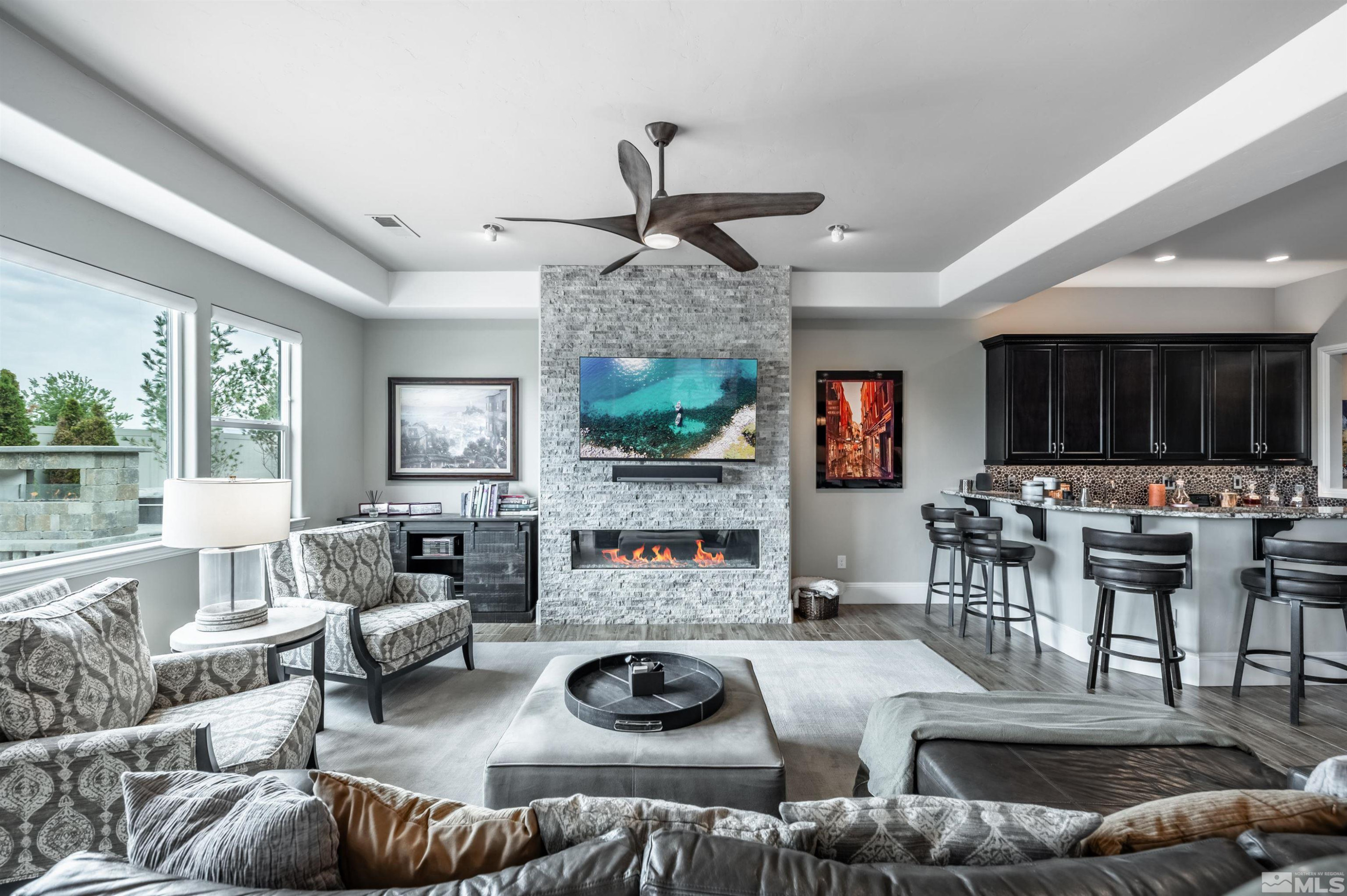 9815 Dyevera Lane Reno, NV 89521 - Photo 19 of 39 a living room with furniture a flat screen tv and a large window