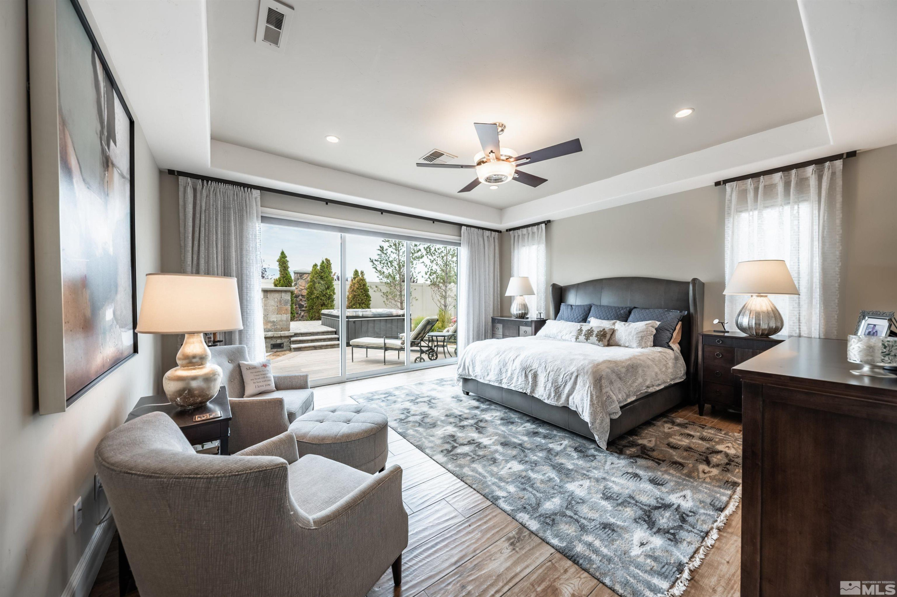 9815 Dyevera Lane Reno, NV 89521 - Photo 22 of 39 a bedroom with a large bed and a chandelier