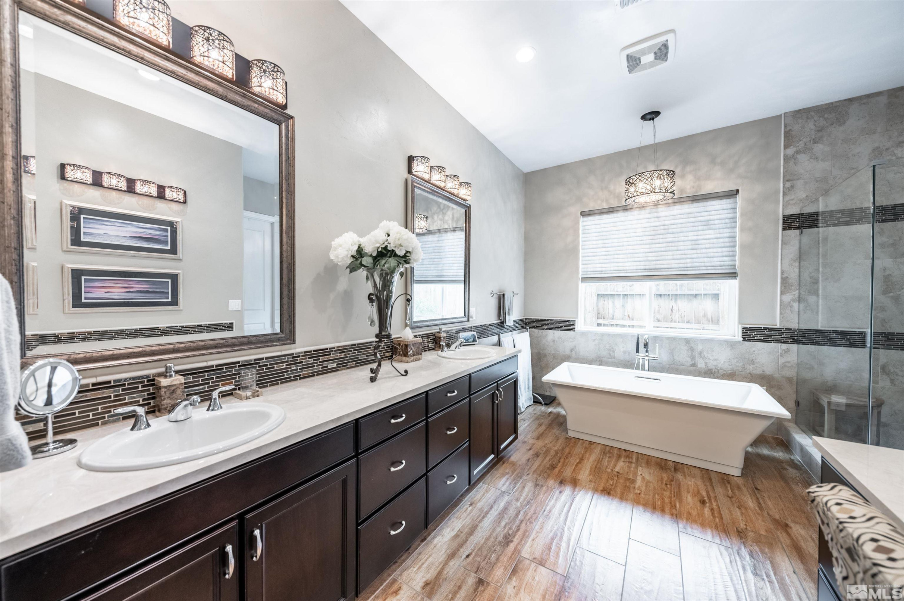 9815 Dyevera Lane Reno, NV 89521 - Photo 24 of 39 a spacious bathroom with a double vanity sink large mirror and a bathtub
