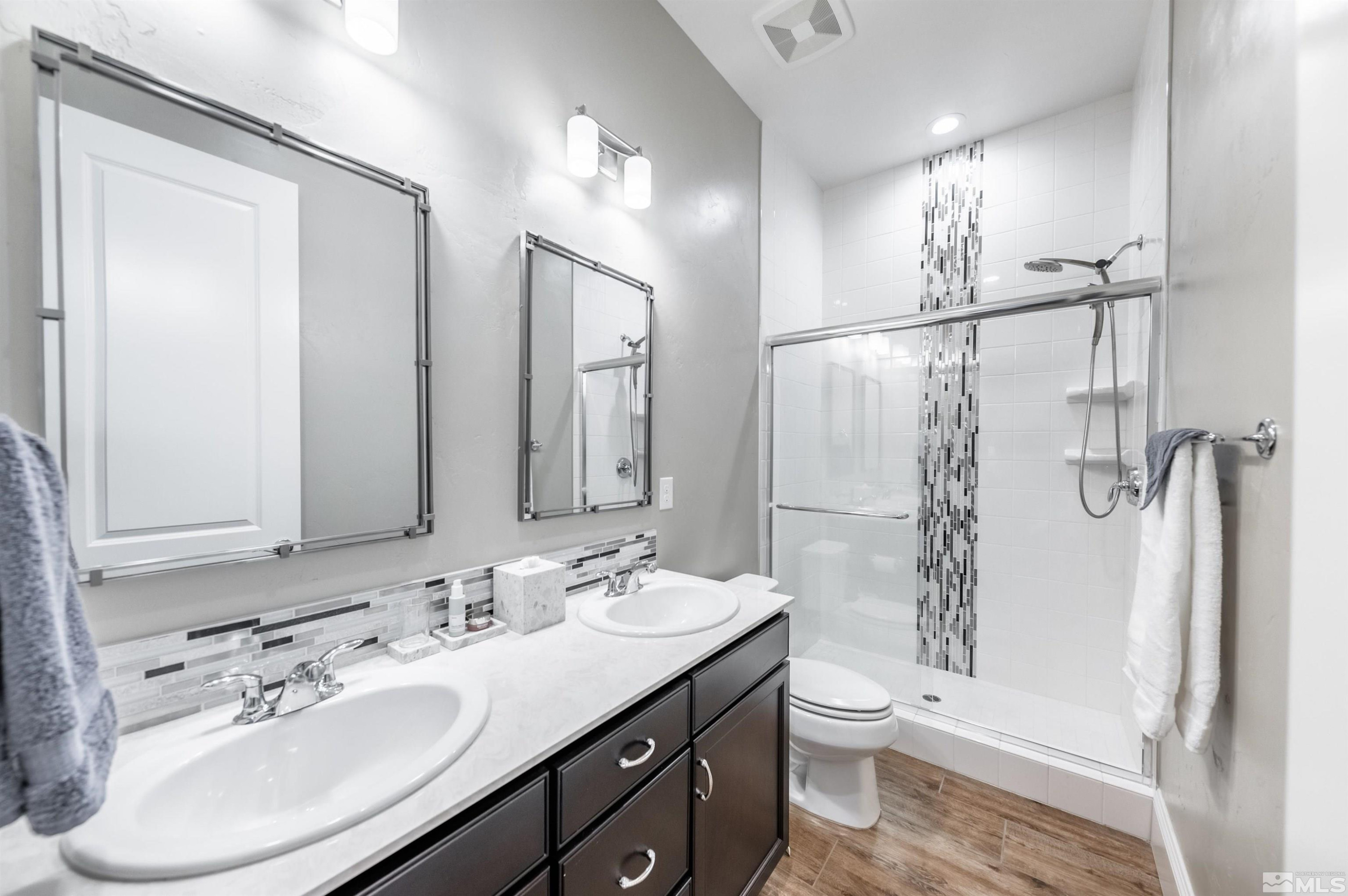 9815 Dyevera Lane Reno, NV 89521 - Photo 28 of 39 a bathroom with a double vanity sink toilet mirror and shower