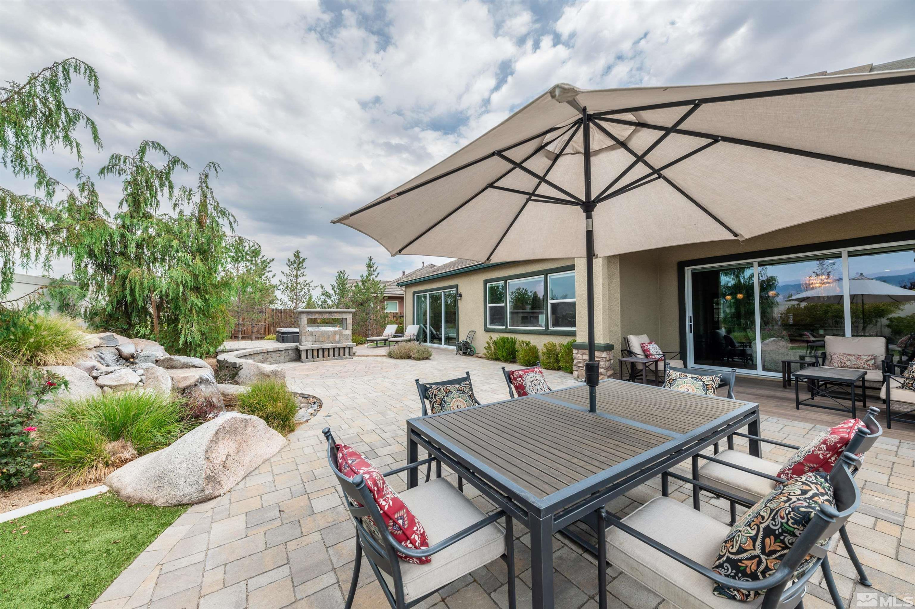 9815 Dyevera Lane Reno, NV 89521 - Photo 34 of 39 a view of a patio with a dining table and chairs under an umbrella