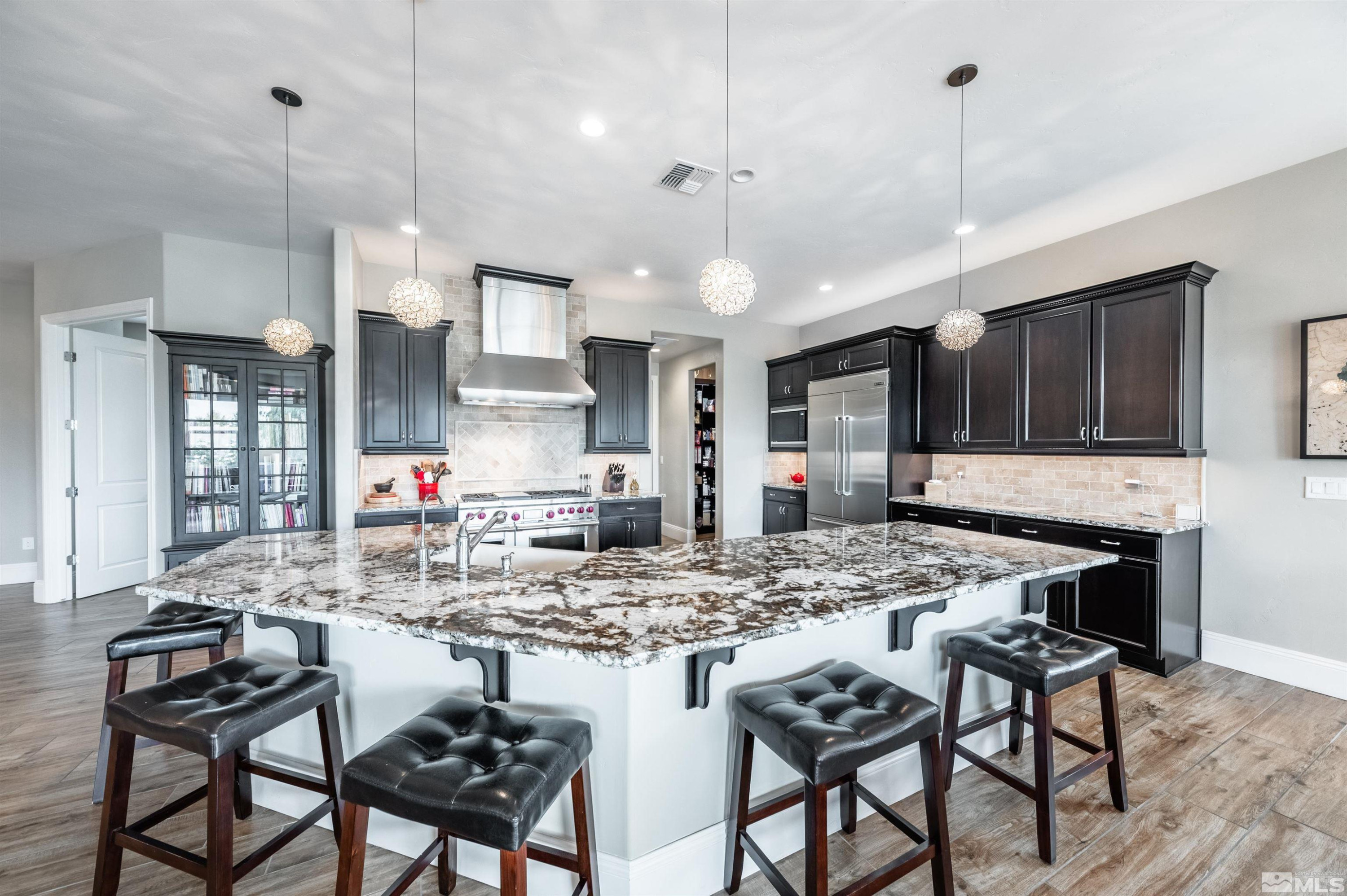 9815 Dyevera Lane Reno, NV 89521 - Photo 9 of 39 a kitchen with stainless steel appliances kitchen island granite countertop a stove a sink and a refrigerator