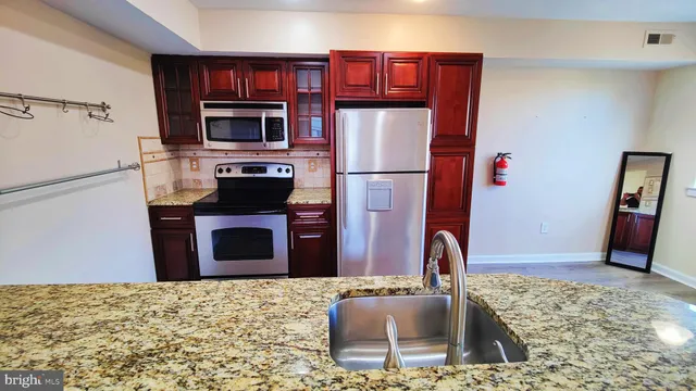 a kitchen with stainless steel appliances granite countertop a refrigerator stove and oven