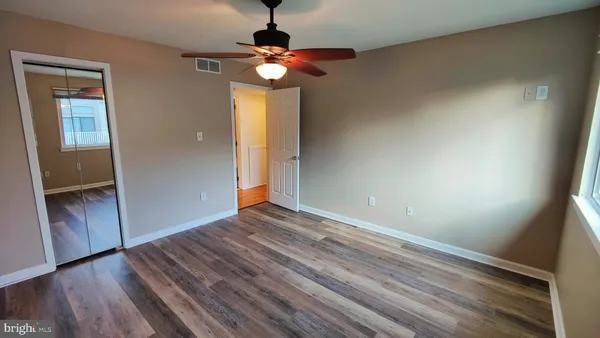 a view of empty room with wooden floor