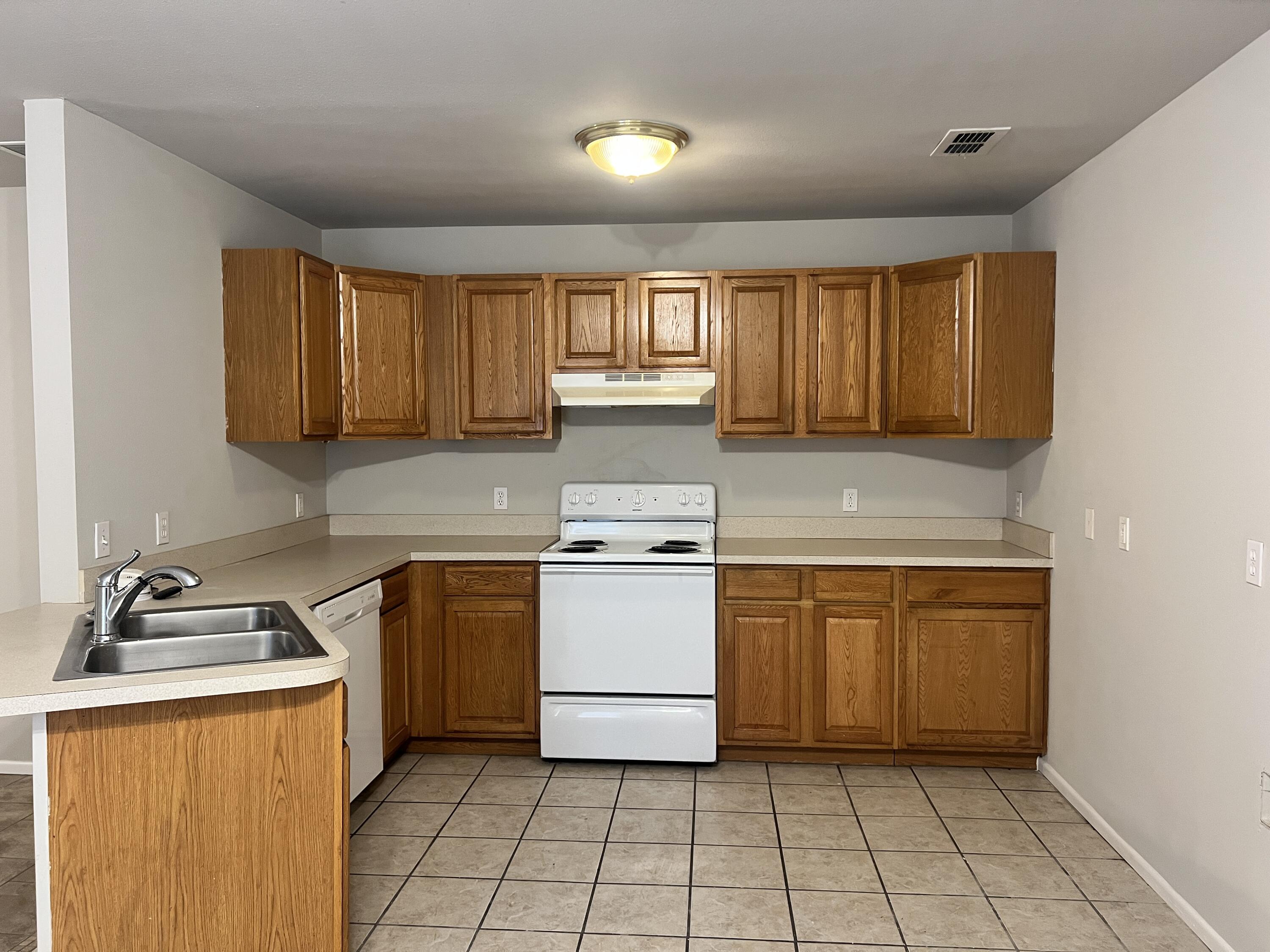 3415 49th Street, Unit B Lubbock, TX 79413 - Photo 4 of 17 a kitchen with a stove sink and cabinets