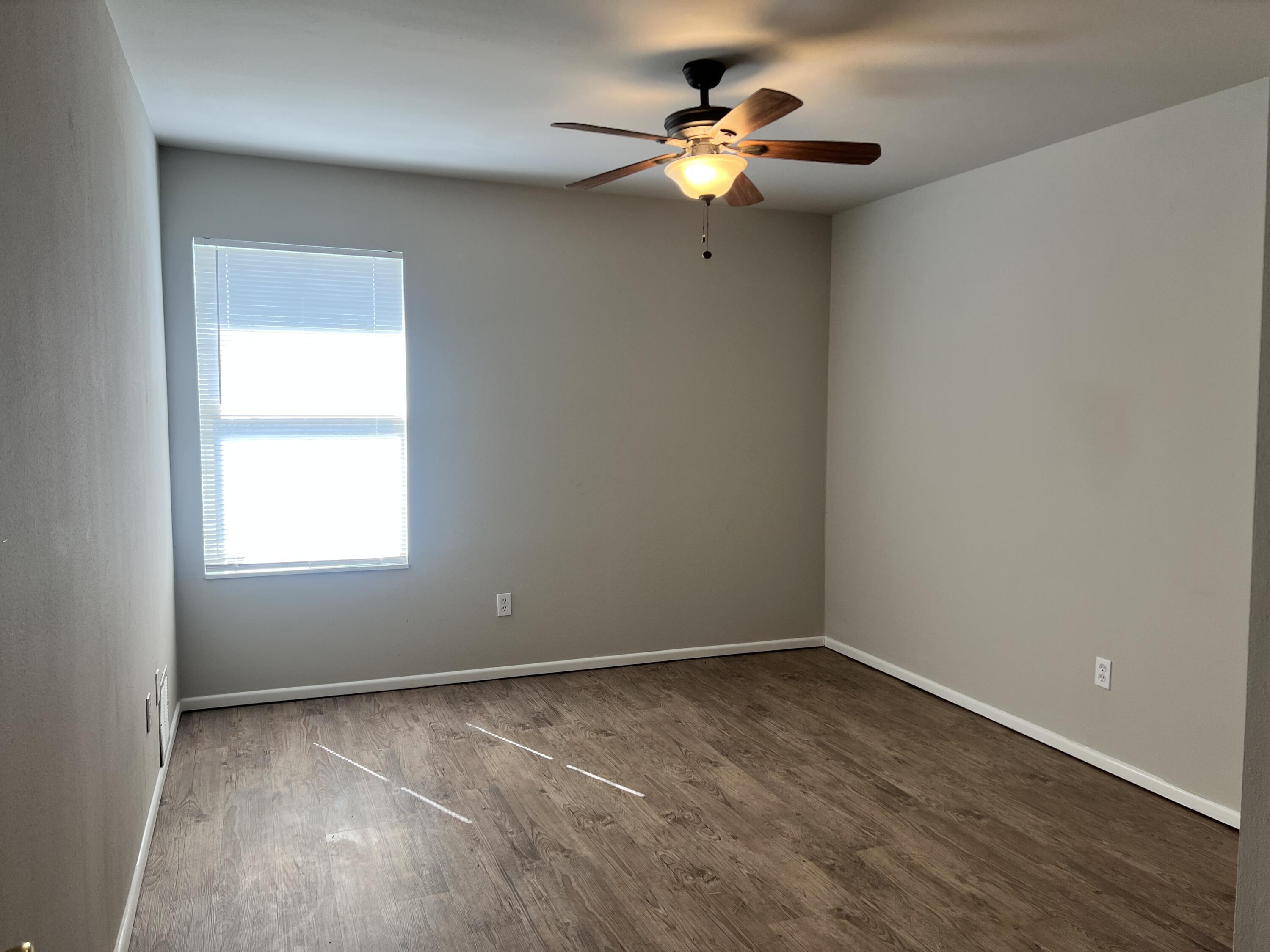 3415 49th Street, Unit B Lubbock, TX 79413 - Photo 9 of 17 an empty room with a window and a fan