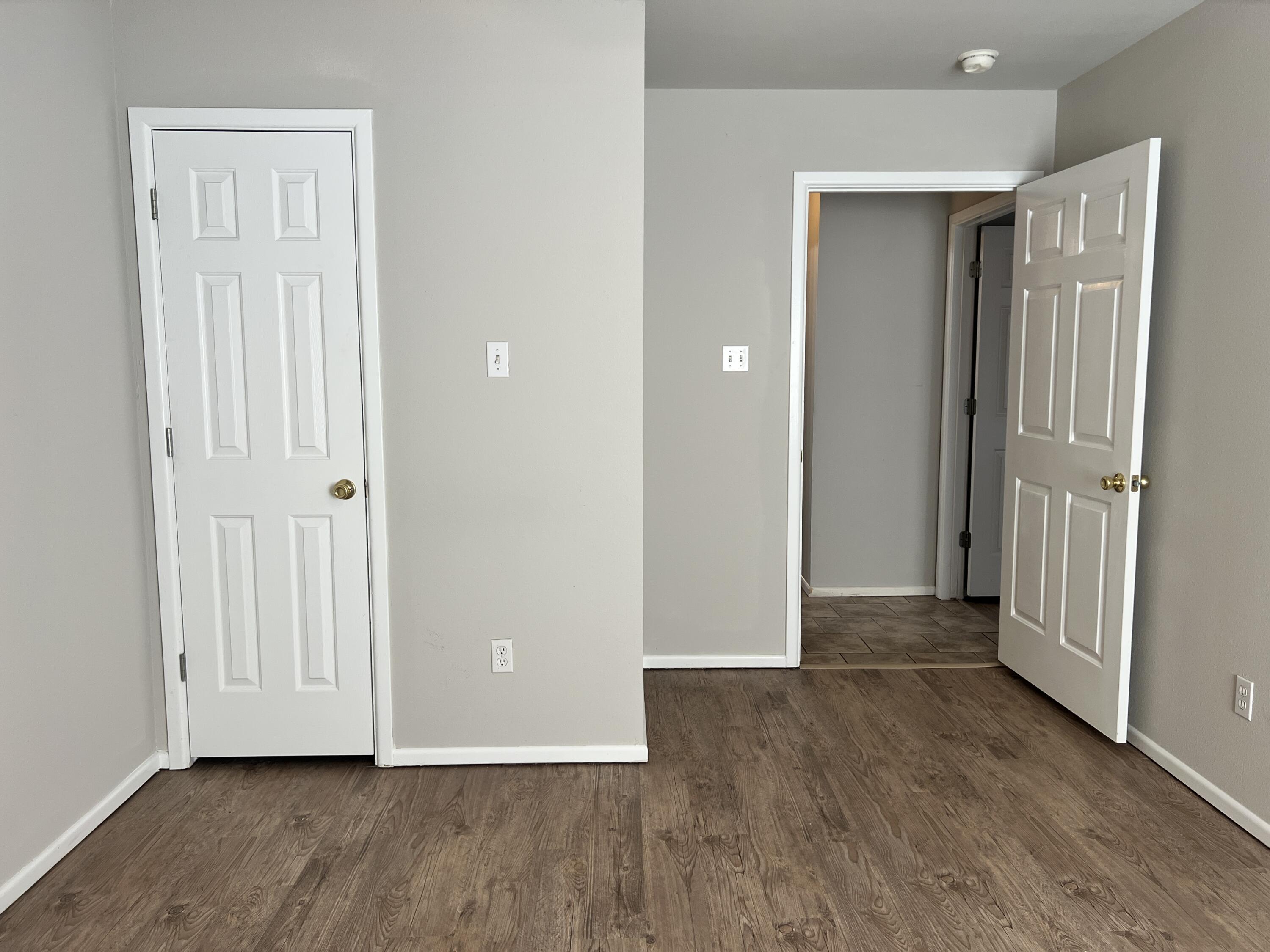 3415 49th Street, Unit B Lubbock, TX 79413 - Photo 10 of 17 an empty room with wooden floor & closet area