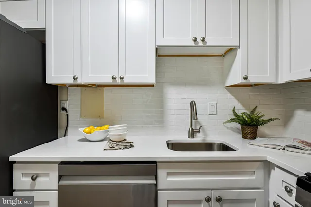 a kitchen with stainless steel appliances granite countertop a sink and a white cabinets