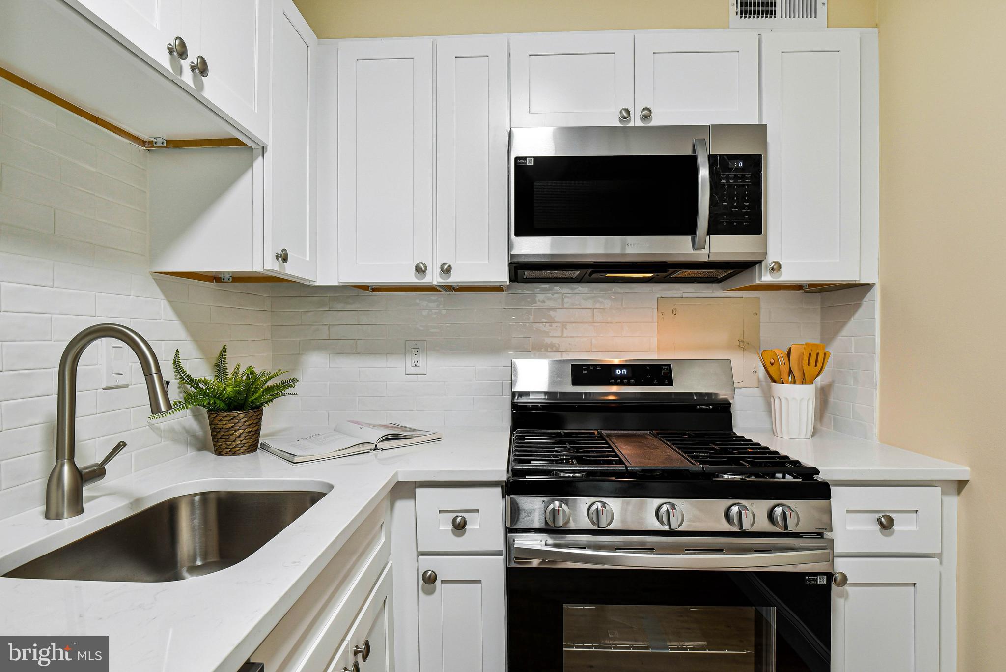 300 M Street Southwest, Unit N508 Washington, DC 20024 - Photo 12 of 32 a kitchen with a stove and a microwave