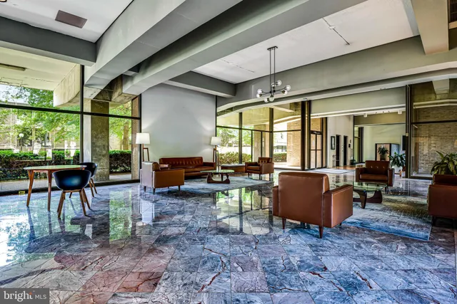 a living room with furniture a fireplace and large windows