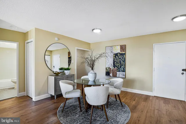 a living room with furniture a mirror and a wooden floor