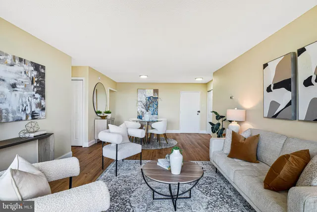 a living room with furniture kitchen view and a window