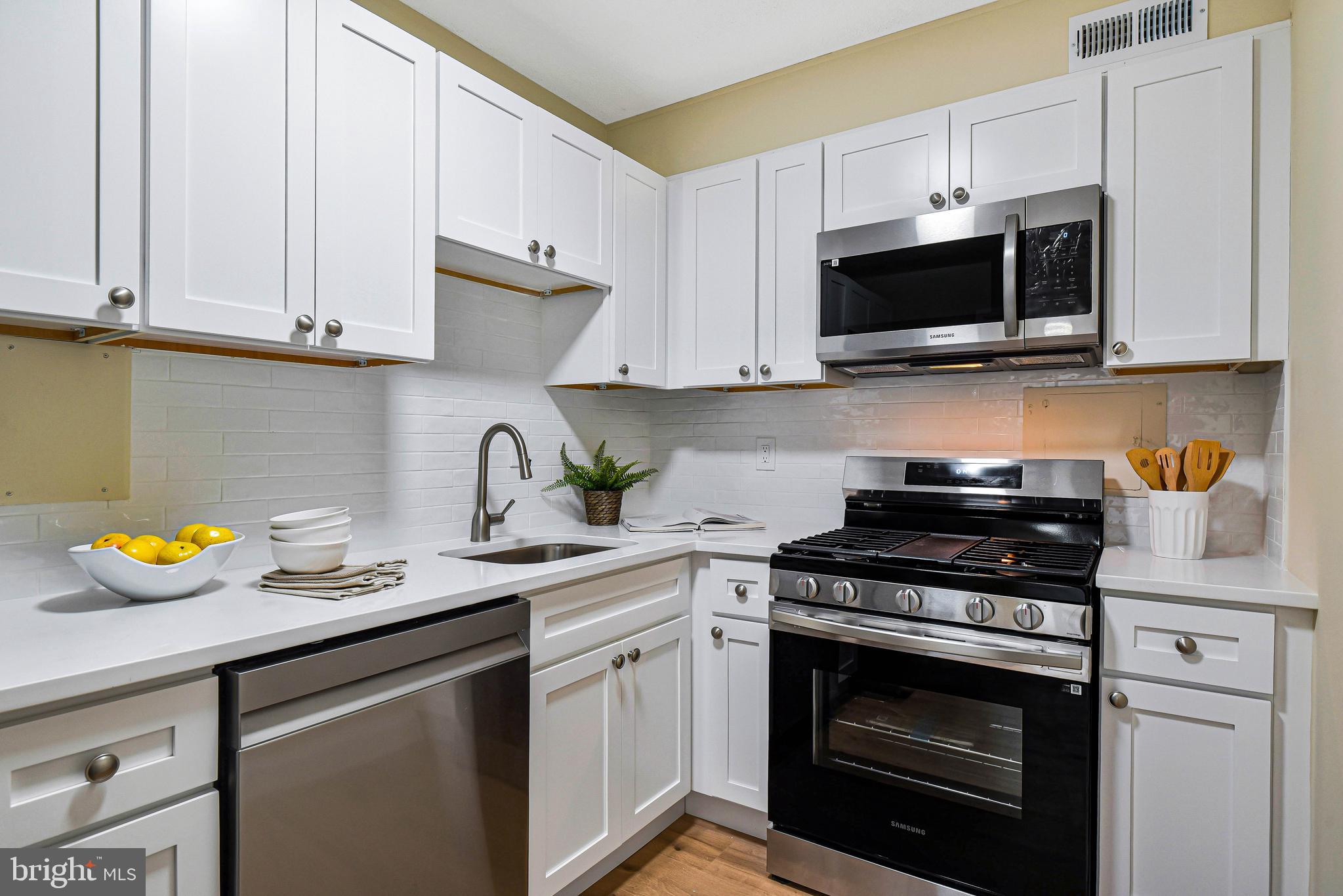 300 M Street Southwest, Unit N508 Washington, DC 20024 - Photo 9 of 32 a kitchen with stainless steel appliances granite countertop a sink a stove a microwave and cabinets