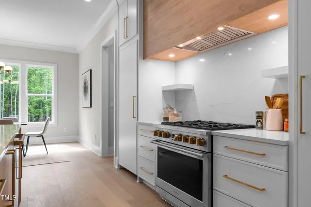 a kitchen with a stove a refrigerator a sink and a large window