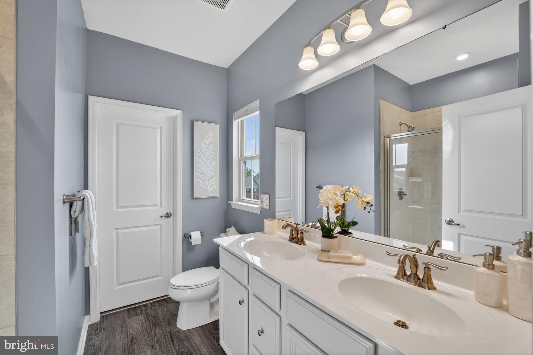 3111 Potters Hill Road Hanover, MD 21076 - Photo 17 of 40 a bathroom with a toilet a sink and a large mirror