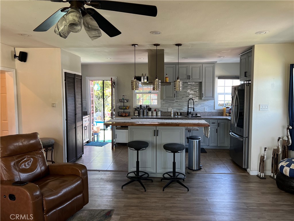 10709 Wheelock Circle Whittier, CA 90606 - Photo 21 of 34 a kitchen with stainless steel appliances kitchen island granite countertop a refrigerator a stove a sink and a dining table with wooden floor