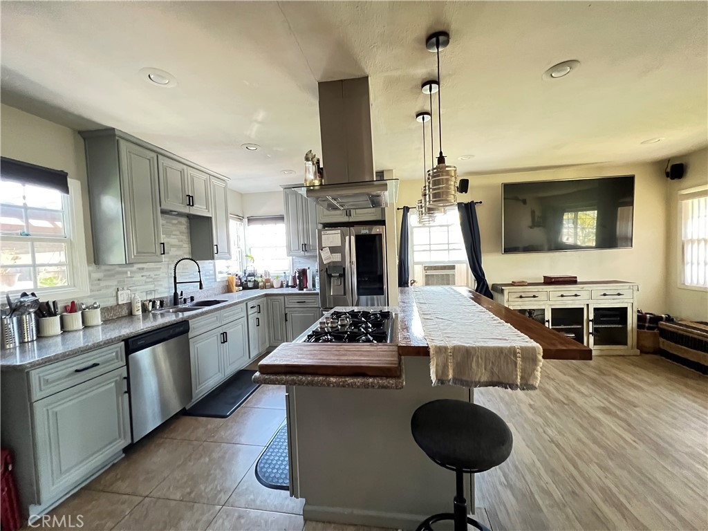 10709 Wheelock Circle Whittier, CA 90606 - Photo 23 of 34 a kitchen with stainless steel appliances granite countertop a stove top oven a sink dishwasher and cabinets with wooden floor