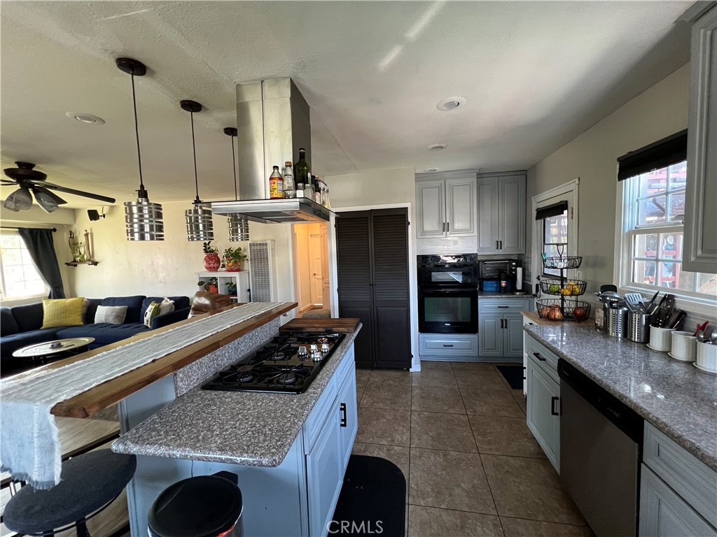 10709 Wheelock Circle Whittier, CA 90606 - Photo 25 of 34 a kitchen with kitchen island granite countertop a sink counter top space appliances and cabinets