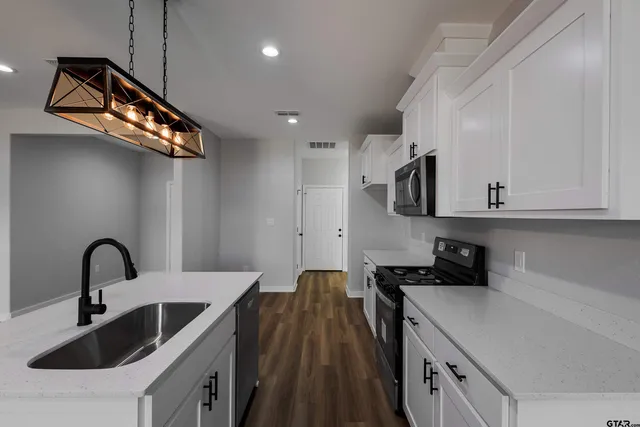 a kitchen with cabinets a sink and appliances