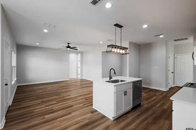 a kitchen that has a sink stainless steel appliances and cabinets