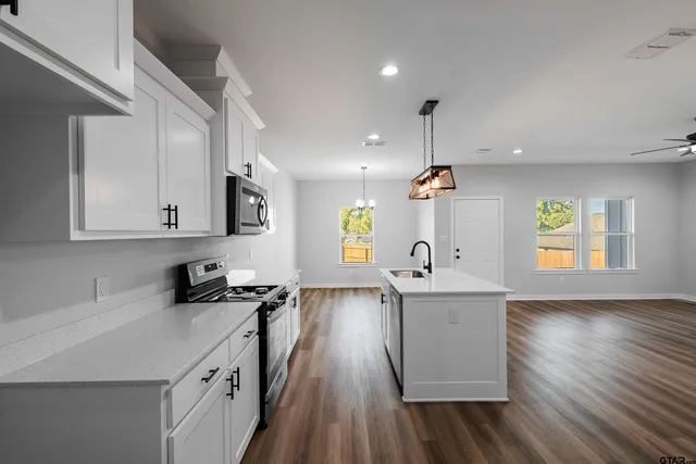 a very nice looking room with wooden floor and cabinets