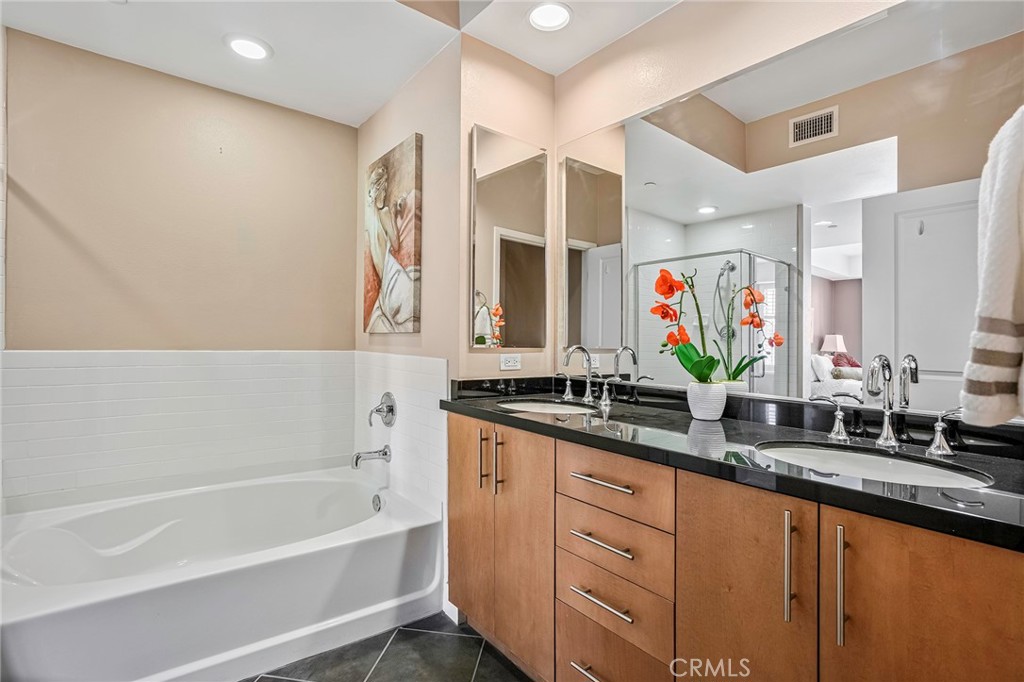 150 The Promenade North, Unit 202 Long Beach, CA 90802 - Photo 18 of 59 a bathroom with a granite countertop sink mirror and a bathtub