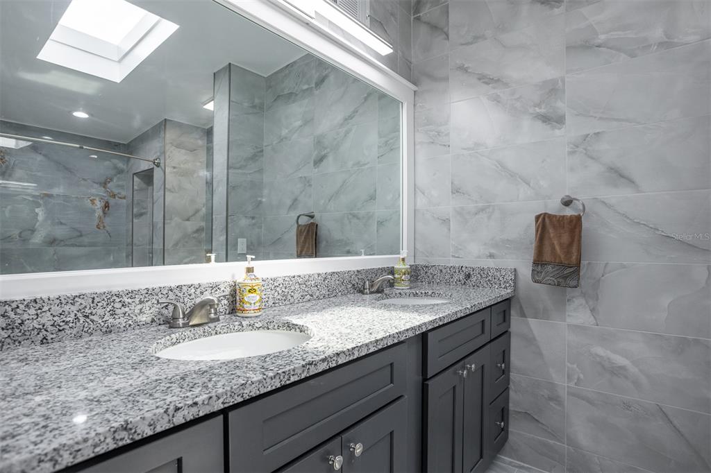1231 Sidcup Road Maitland, FL 32751 - Photo 20 of 39 a bathroom with a granite countertop sink a mirror and shower