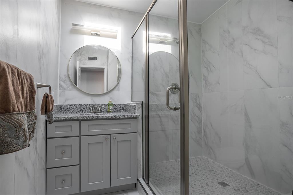 1231 Sidcup Road Maitland, FL 32751 - Photo 23 of 39 a bathroom with a granite countertop sink a mirror and shower
