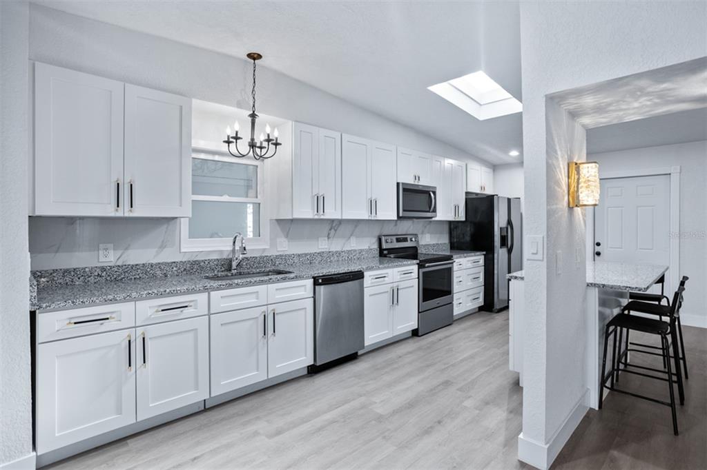 1231 Sidcup Road Maitland, FL 32751 - Photo 3 of 39 a kitchen with kitchen island granite countertop a sink cabinets and stainless steel appliances