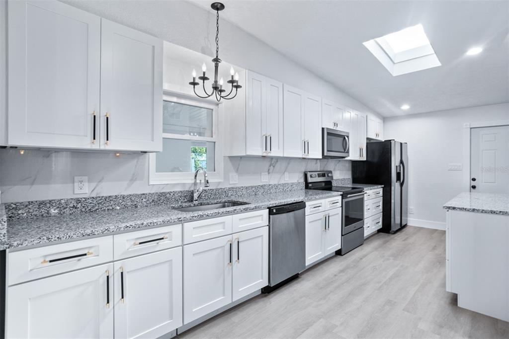 1231 Sidcup Road Maitland, FL 32751 - Photo 5 of 39 a kitchen with stainless steel appliances granite countertop a sink a stove a refrigerator and white cabinets