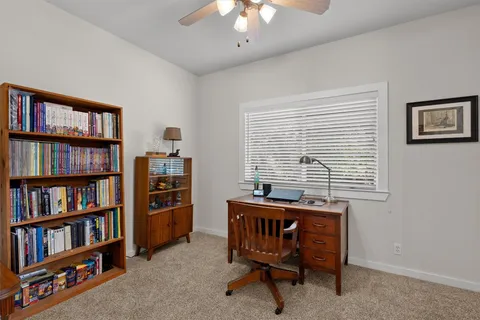 a view of a workspace with a bookshelf and a window