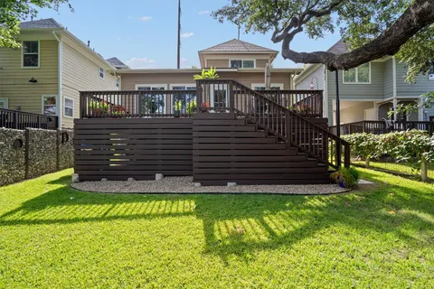 a view of a house with a small yard and a large tree