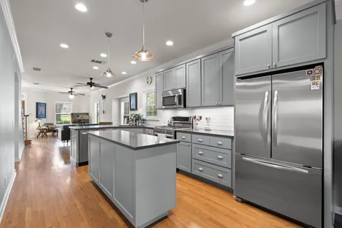 a kitchen with kitchen island a counter top space a sink stainless steel appliances and cabinets