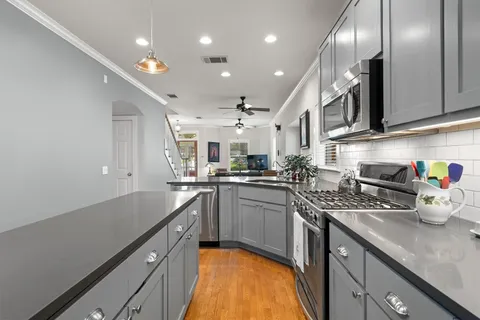 a kitchen with stainless steel appliances a stove a sink and a microwave