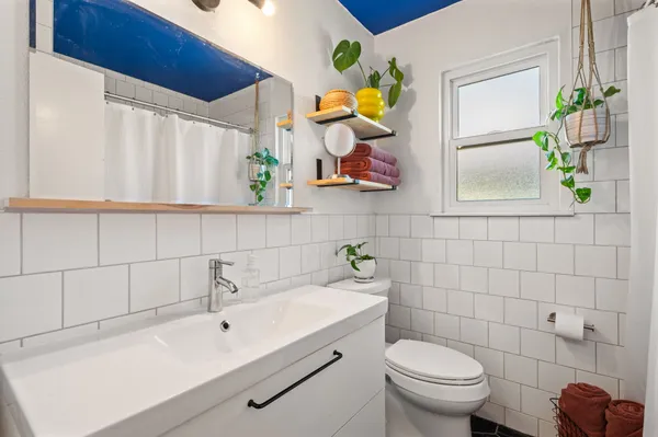 a bathroom with a sink mirror and toilet