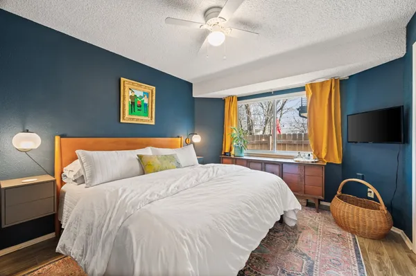 a bedroom with bed tv and window