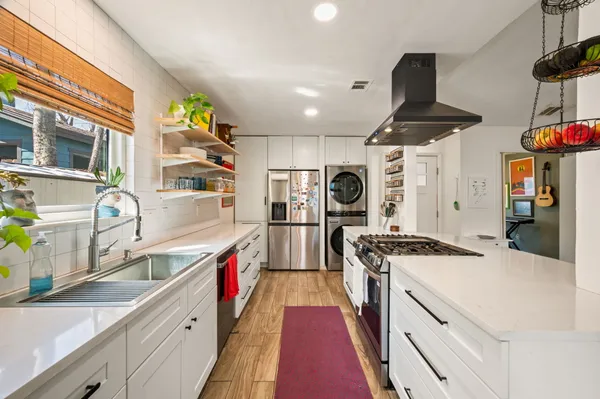 a kitchen with stainless steel appliances granite countertop a sink a stove and a refrigerator