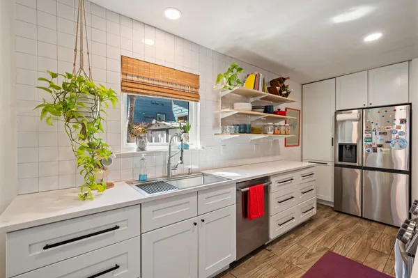 a kitchen with stainless steel appliances white cabinets and a window