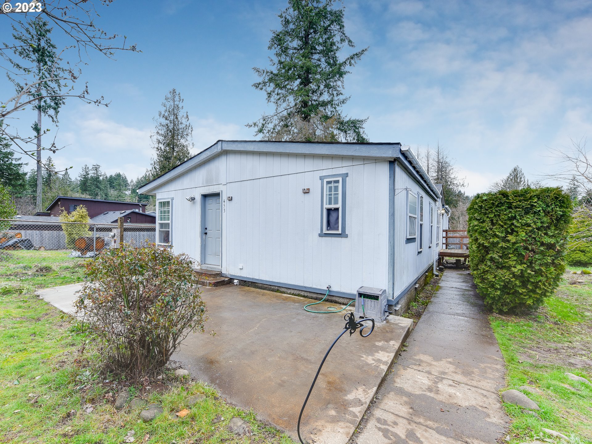 453 Southwest Hawthorn Road Estacada, OR 97023 - Photo 1 of 20 a white house with tree in front of it