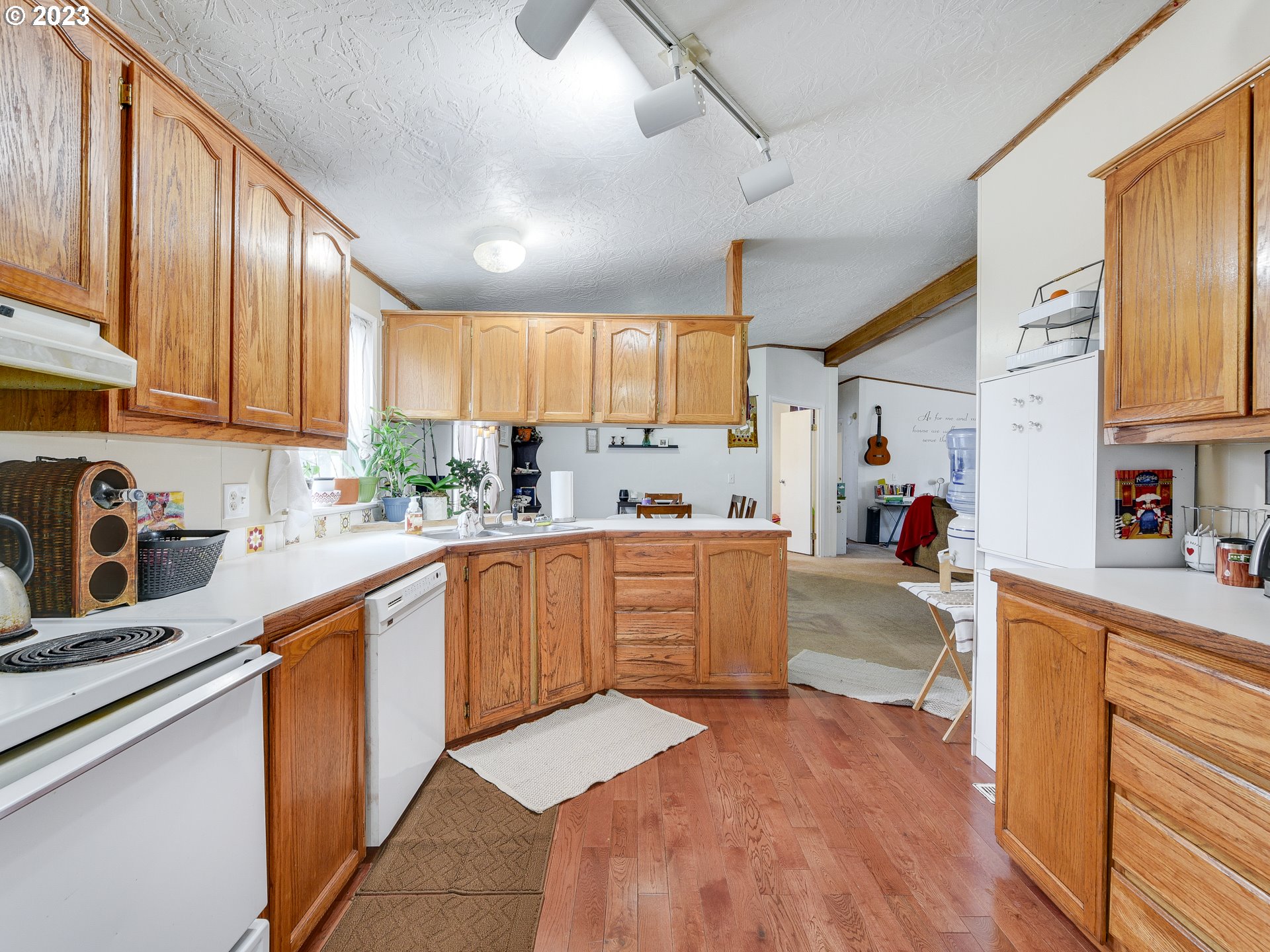 453 Southwest Hawthorn Road Estacada, OR 97023 - Photo 8 of 20 a kitchen with stainless steel appliances kitchen island granite countertop a sink dishwasher stove top oven and cabinets with wooden floor