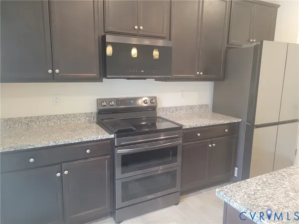 a kitchen with granite countertop a stove and a sink
